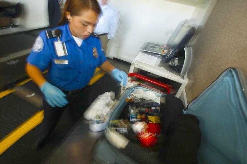 What's in that suitcase? A TSA officer hand-inspects a traveler's bag after an alarm sounded on an X-ray machine. Chocolate and cheese commonly trigger the machines because the two foods have the same density as explosives.