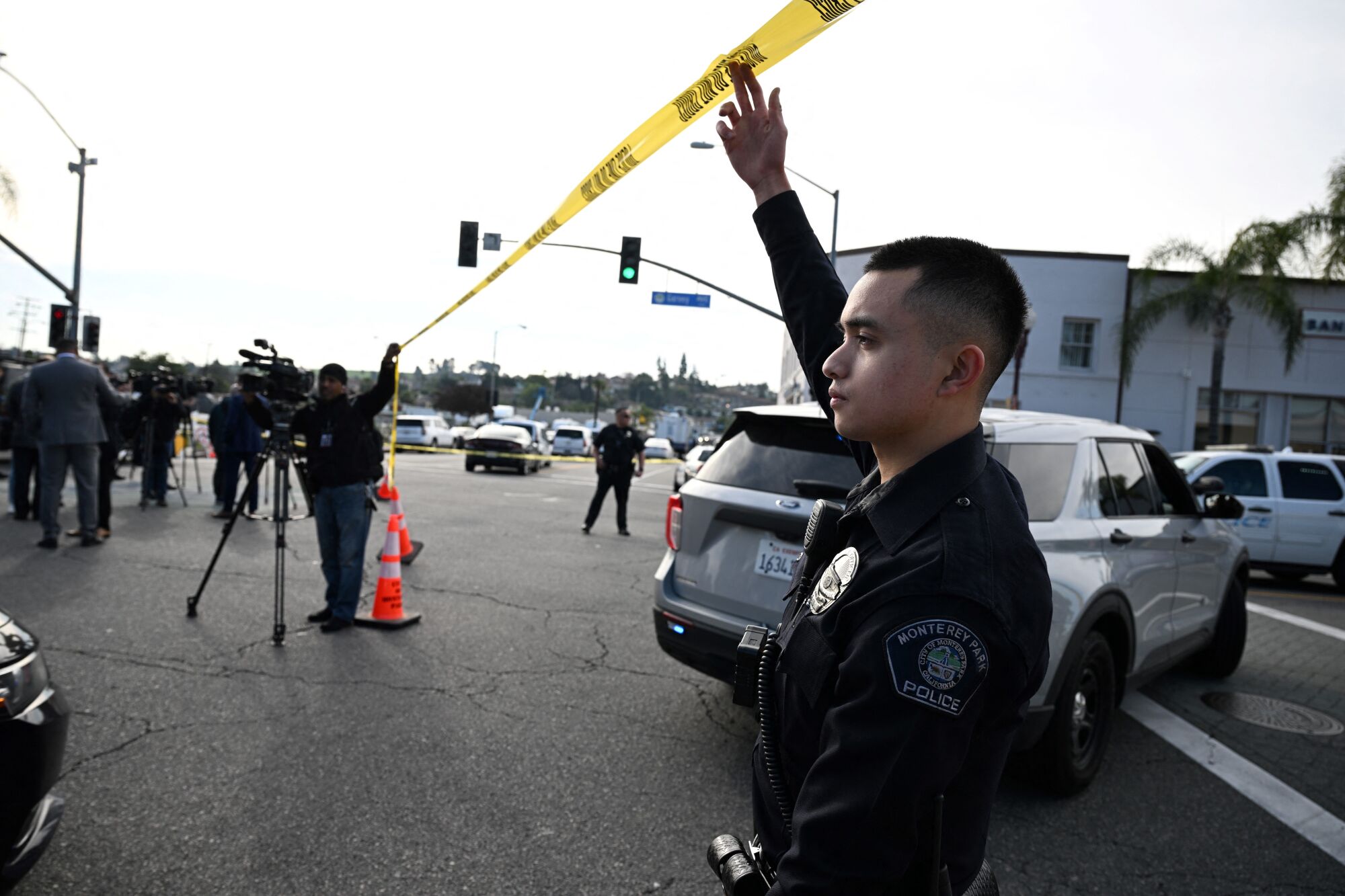 An officer lifts police tape for investigators.