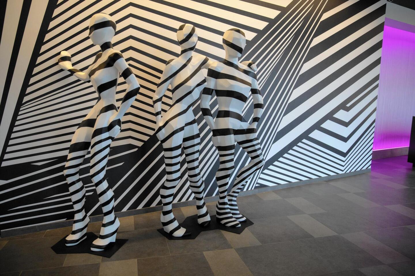 Eight-foot-tall mannequins covered in black-and-white “dazzle camouflage” greet guests in the lobby of The Rose.