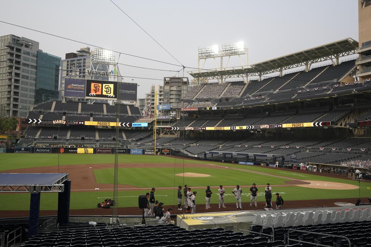 San Francisco players stand near the dugout as the team's game against the San Diego is postponed Friday, Sept. 11, 2020.