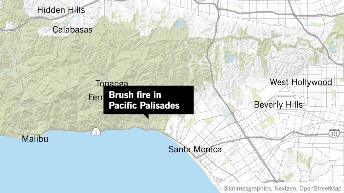Firefighters were battling a fast-moving brush fire that had grown to 30 acres and was threatening homes in Pacific Palisades.