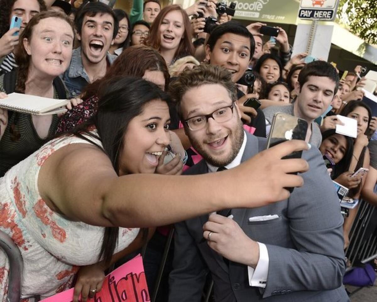 A fan takes a picture with Seth Rogen at the premiere for "This Is the End" in Westwood.