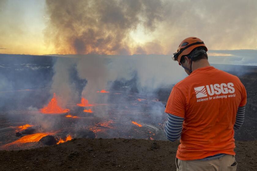 In this photo provided by the U.S. Geological Survey, a scientist monitors the ongoing eruption taking place on the summit of the Kilauea volcano in Hawaii, Wednesday, June 7, 2023. Hawaii tourism officials urged tourists to be respectful when flocking to a national park on the Big Island to get a glimpse of the latest eruption of Kilauea, one of the world's most active volcanoes. (U.S. Geological Survey via AP)