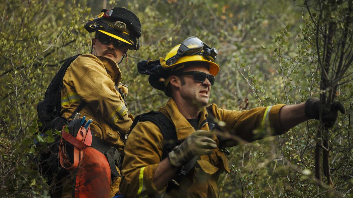 Alameda County firefighters Robert Groh, left, and Darryn Murphy, right, clear brush as they work with other firefighters in the Santa Ynez mountains in preparations for sundowner winds near Montecito.