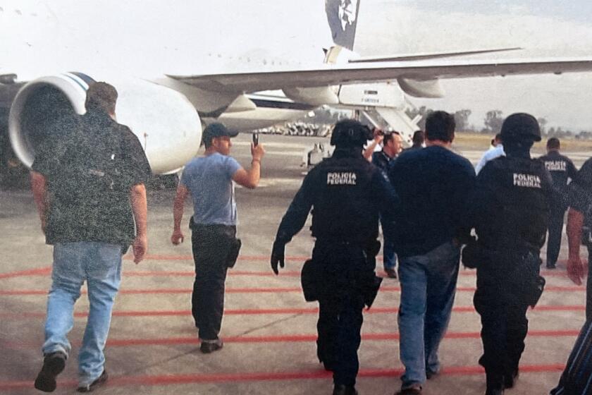 A photo presented in court as evidence shows Jose Saenz, flanked by FBI agents, when he was arrested in Guadalajara in 2012, 14 years after he went on the run. Caption: Los Angeles Superior Court