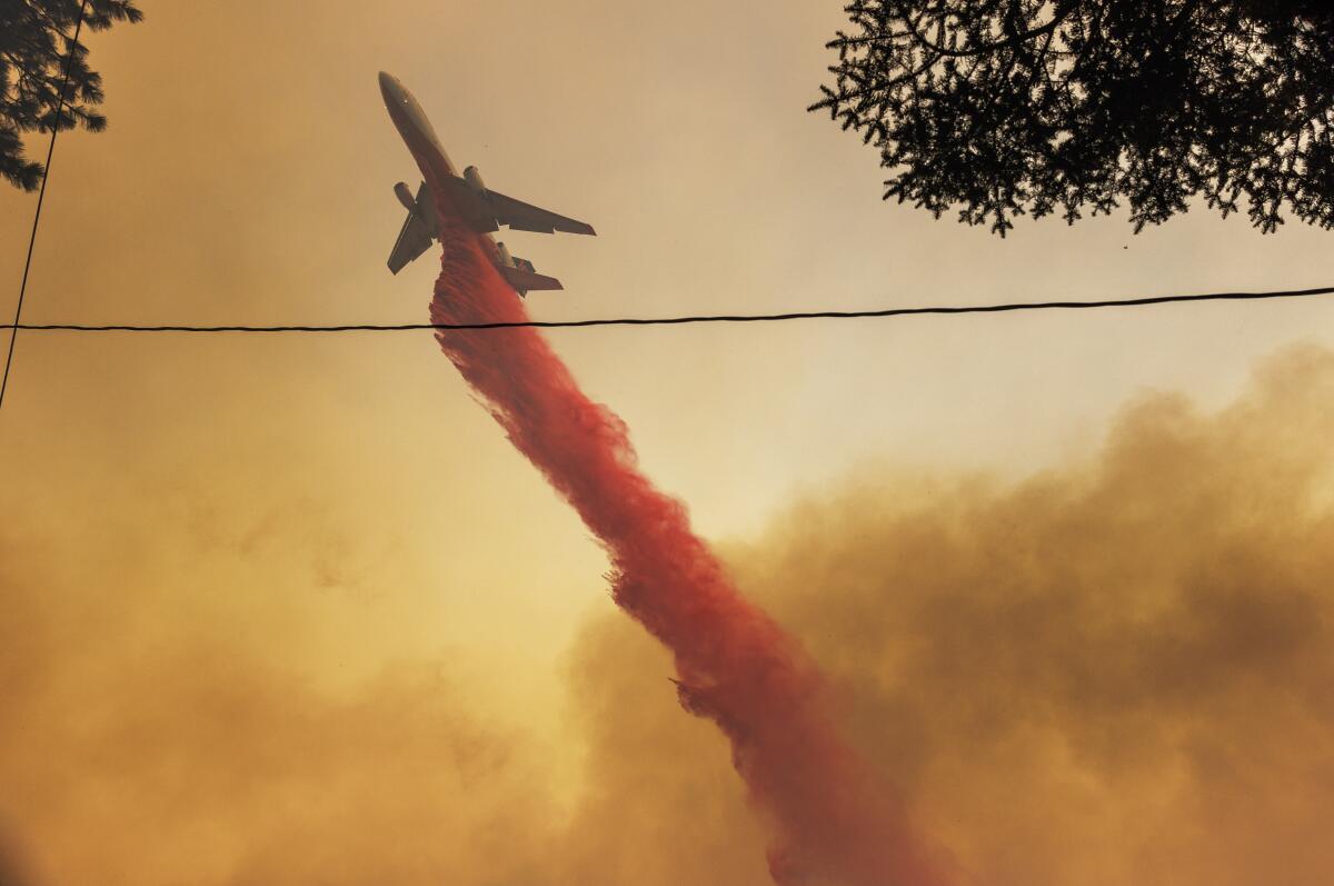 An air tanker drops fire retardant on the Line fire as it burns close to homes in Running Springs.