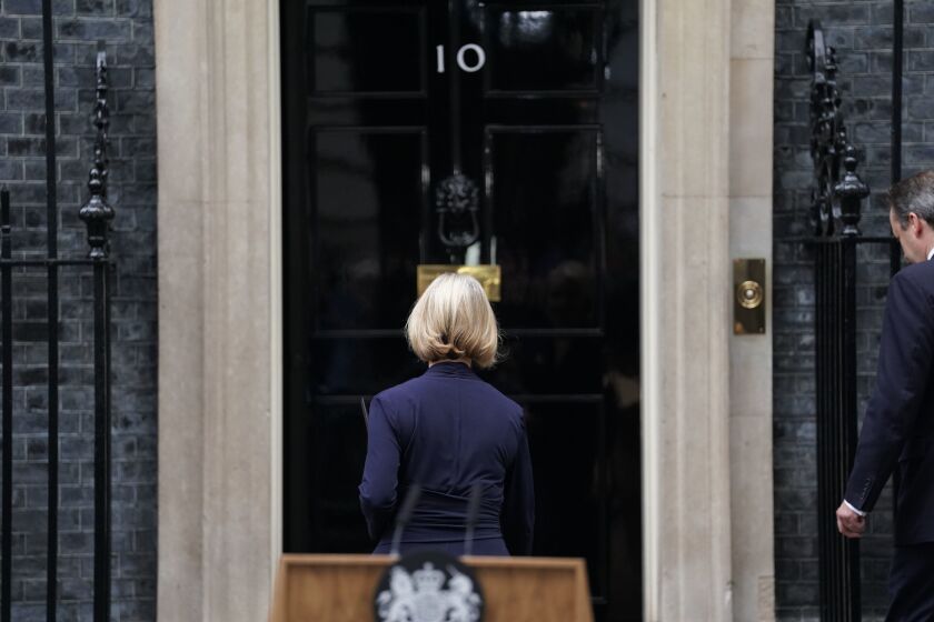 Liz Truss, followed by her husband Hugh O'Leary, right, walks back into 10 Downing Street after making a statement where she announced her resignation as Prime Minister, in London, Thursday Oct. 20, 2022. Truss resigned Thursday, bowing to the inevitable after a tumultuous, short-lived term in which her policies triggered turmoil in financial markets and a rebellion in her party that obliterated her authority. (Stefan Rousseau/PA via AP)