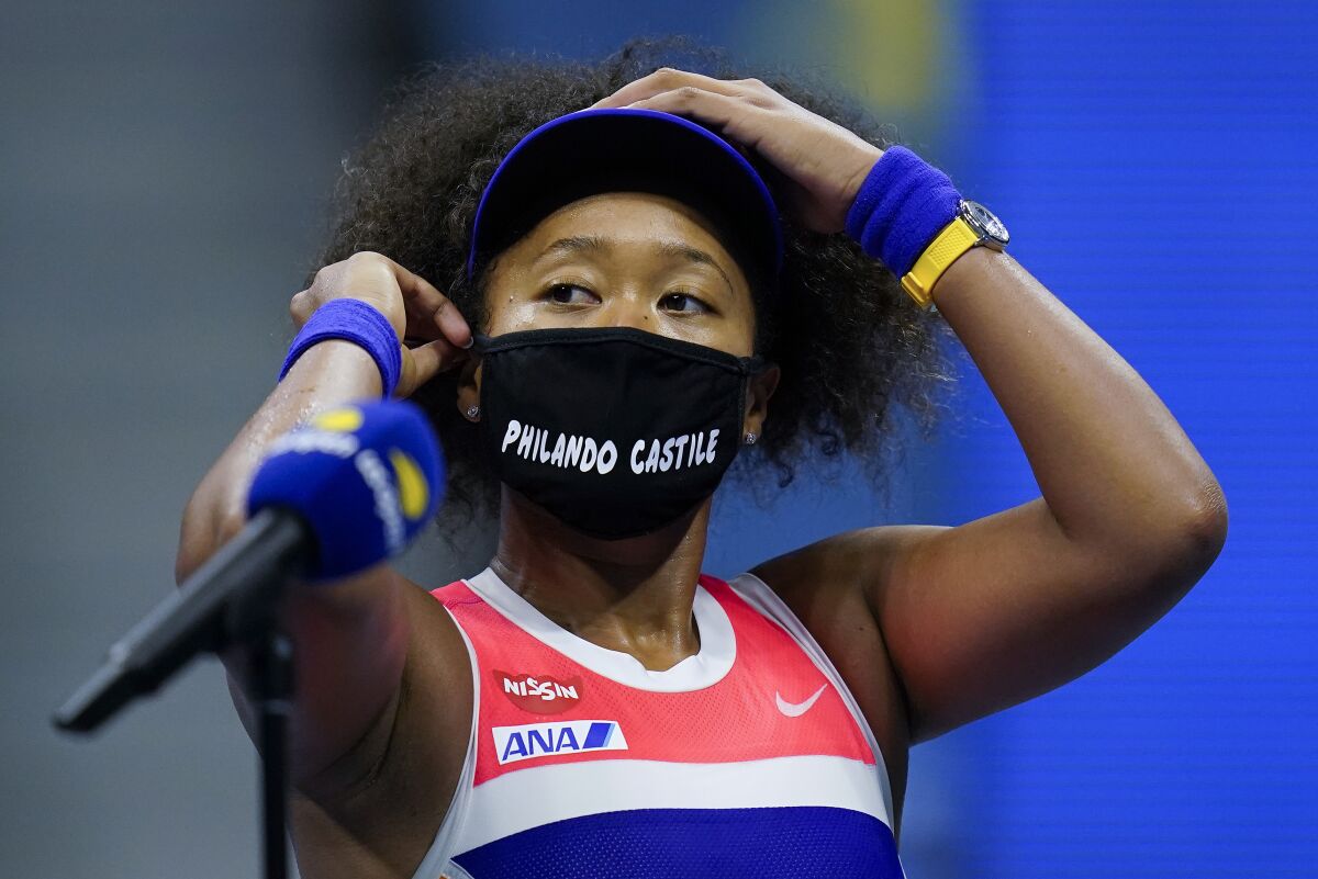 Naomi Osaka  adjusts her mask during a semifinal match of the U.S. Open tennis championships.
