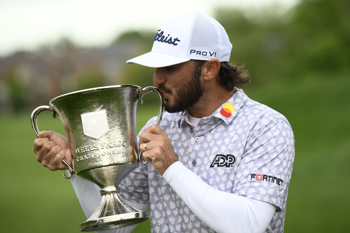 Max Homa kisses the trophy after winning the Wells Fargo Championship golf tournament, Sunday, May 8, 2022, at TPC Potomac at Avenel Farm golf club in Potomac, Md. (AP Photo/Nick Wass)