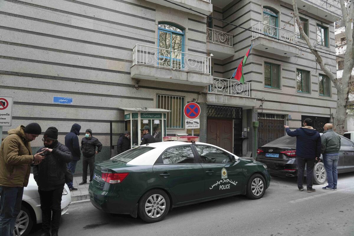 People gather outside of the Azerbaijan Embassy after an attack there in Tehran, Iran, Friday, Jan. 27, 2023. A man armed with a Kalashnikov-style rifle stormed the Azerbaijan Embassy in Iran's capital Friday, killing the head of security at the diplomatic post and wounding two guards, authorities said. (AP Photo/Vahid Salemi)