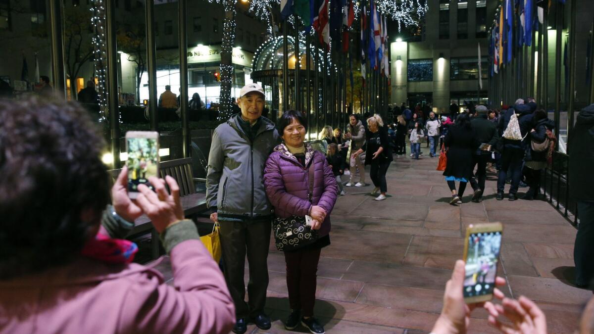 Tourists from China pose for photographs at Rockefeller Center in New York on Nov. 12, 2017.