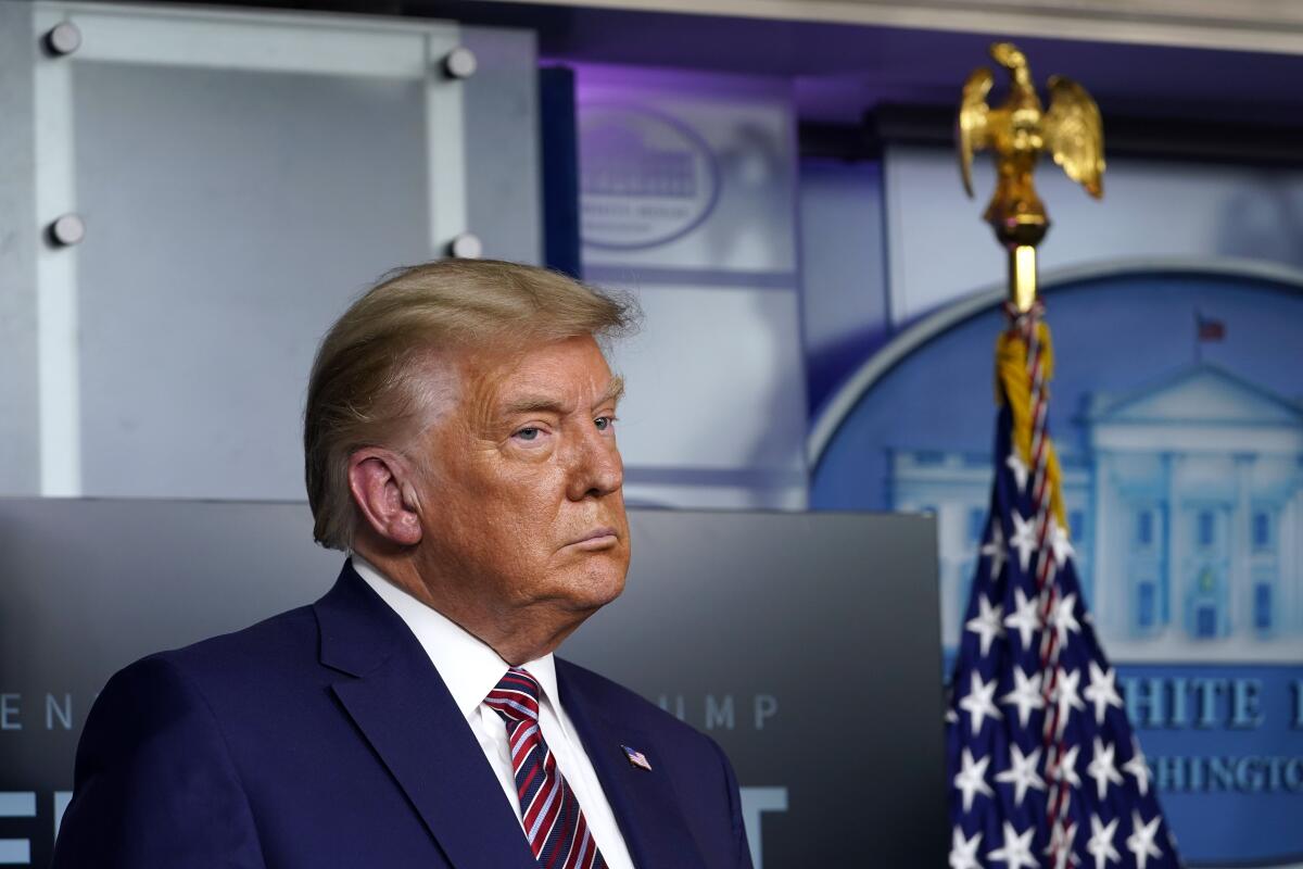 President Trump stands in the White House briefing room