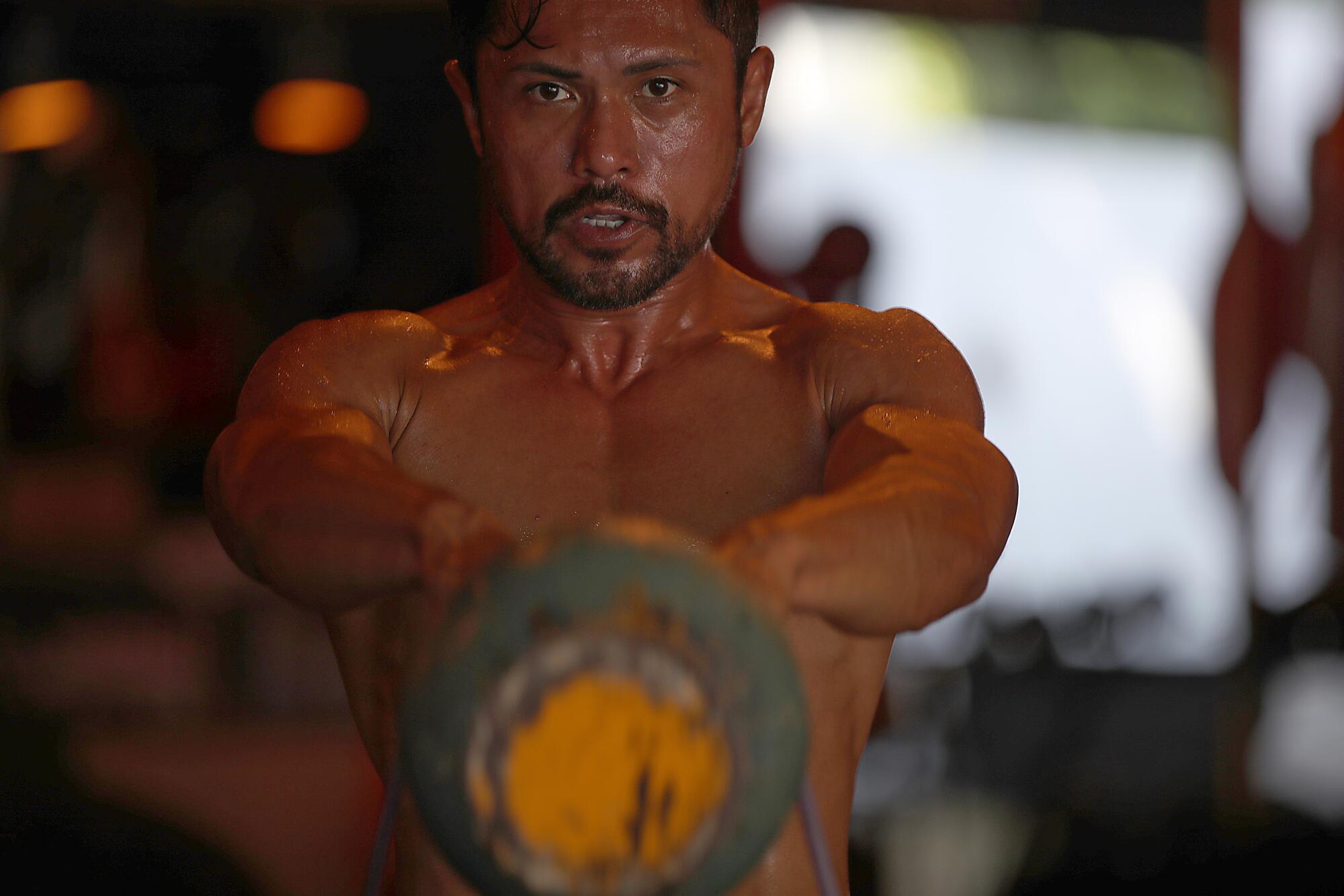 Joel Relampagos working out with weights.