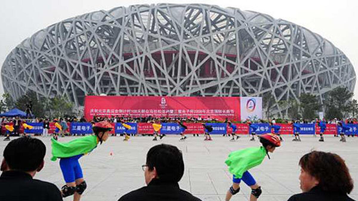 Children on roller-skates give a display in front of the National Stadium, also known as the "Bird's Nest" for its design, ahead of a long-distance race on in Beijing to celebrate 100 days before the start of the Olympic Games on August 8.