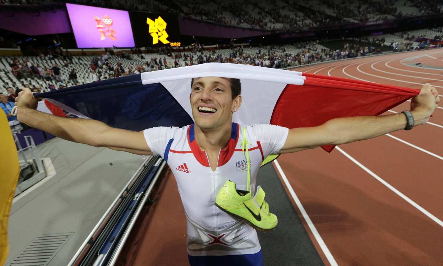 France's Renaud Lavillenie carries his country's flag after winning gold in the men's pole vault final.