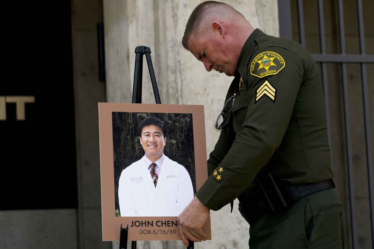 Orange County Sheriff's Sgt. Scott Steinle displays a photo of Dr. John Cheng, a 52-year-old victim who was killed in Sunday's shooting at Geneva Presbyterian Church, during a news conference in Santa Ana, Calif., Monday, May 16, 2022. (AP Photo/Jae C. Hong)