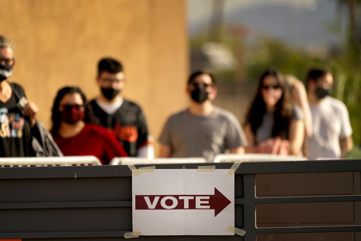 FILE - In this Tuesday, Nov. 3, 2020 file photo, Voters stand in line outside a polling station, on Election Day in Mesa, Ariz. A report released on Wednesday, Sept. 8, 2021 in Arizona’s largest county claims to have uncovered some 173,000 “lost” votes and 96,000 “ghost votes” in a private door-to-door canvassing effort, rendering the 2020 election in Maricopa County “uncertifiable.” But its conclusions aren’t supported with any evidence, according to county election officials and outside election experts, who called the report's sampling methods “quasi-science” and “problematic.”(AP Photo/Matt York, File)