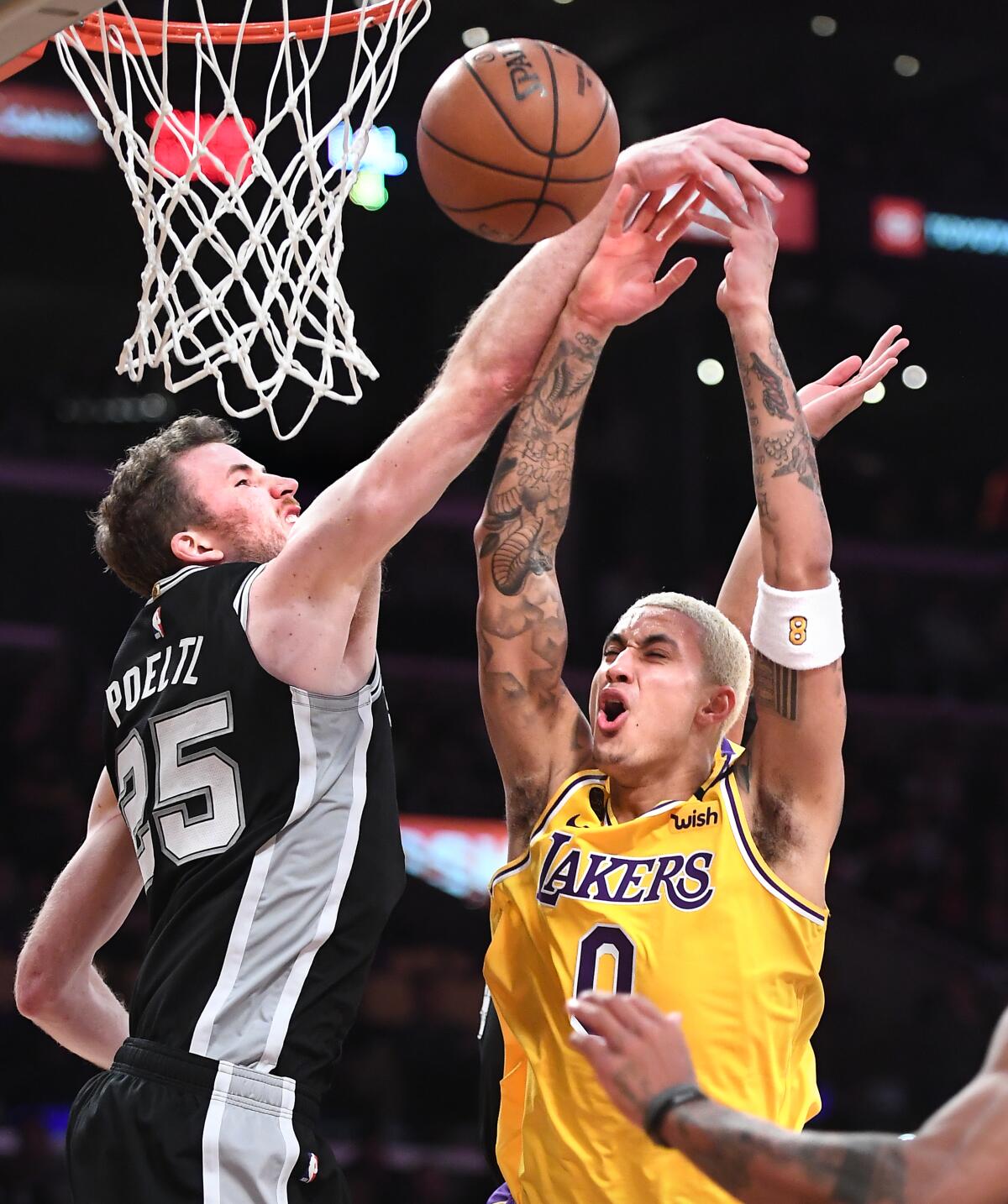 Kyle Kuzma is fouled by the Spurs' Jakob Poeltl while driving to the basket during the fourth quarter of a game Feb. 4 at Staples Center.