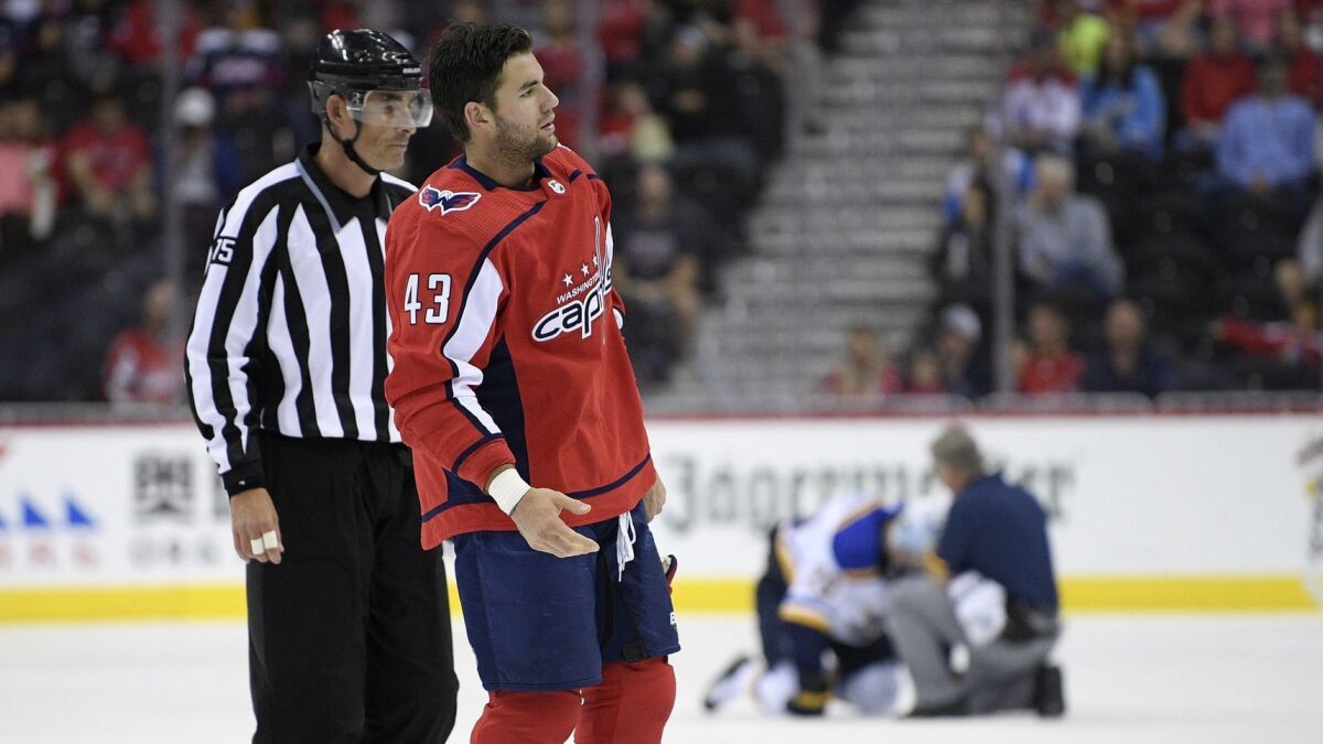 Washington's Tom Wilson is escorted by an official off the ice after he checked St. Louis' Oskar Sundqvist, on ice at back center, on Sept. 30.