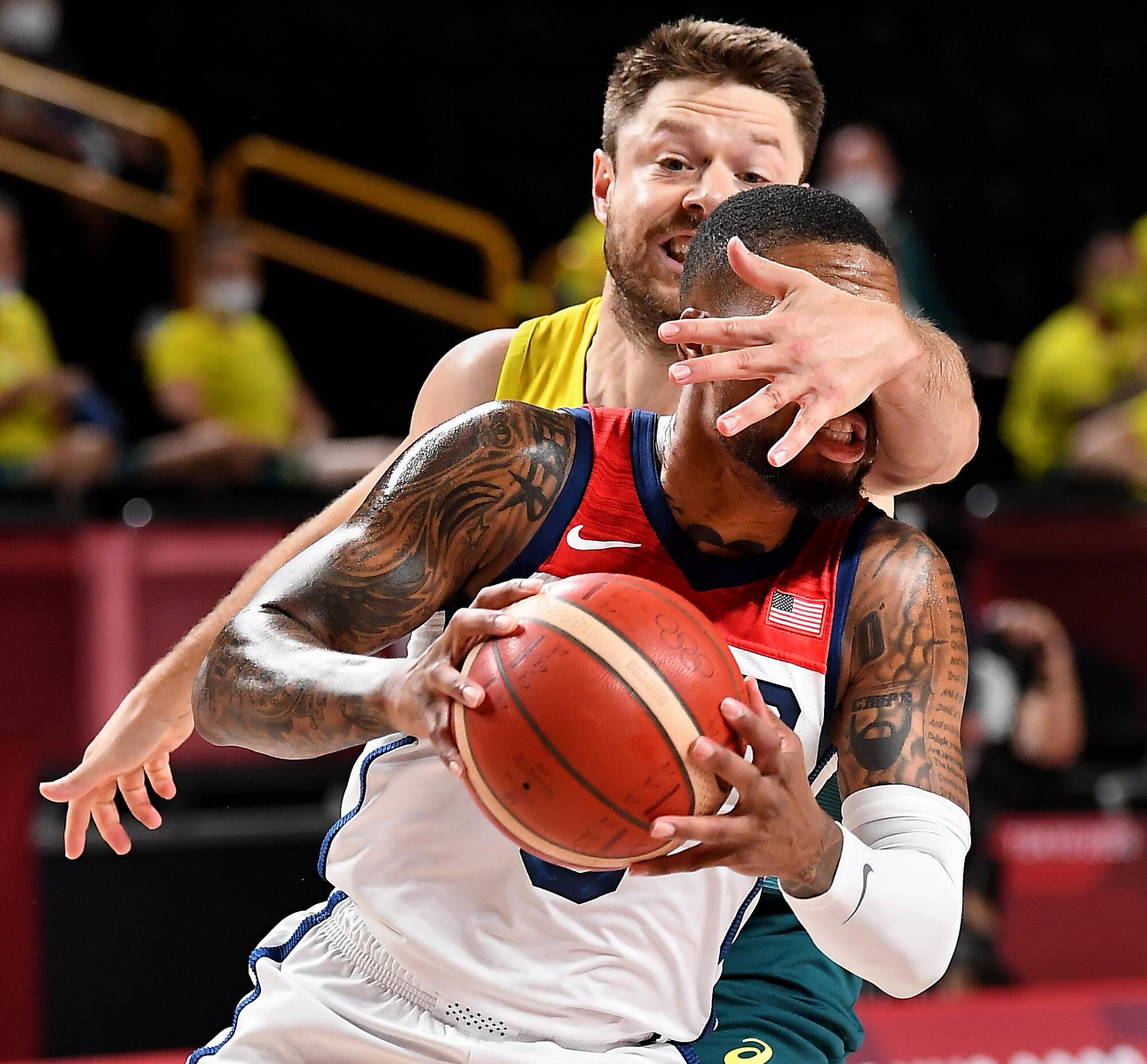 Damian Lillard drives into the arm of Australia’s Matt Dellavedova at the Tokyo Olympics.