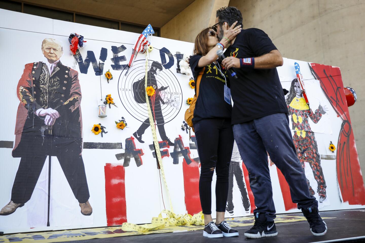 Patricia and Manuel Oliver embrace in front of a mural he created in the memory of their son, Joaquin, and the others killed at the Parkland, Fla., school shooting. The mural was erected Saturday outside the National Rifle Assn. convention in Dallas.