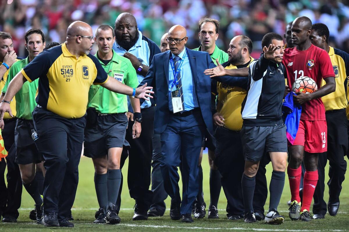 US referee Mark Geiger (3rd L) is escorted by security off the field after a CONCACAF Gold Cup semifinal football match between Mexico and Panama in Atlanta on July 22, 2015 which was marred by several incidents. AFP PHOTO/NICHOLAS KAMMNICHOLAS KAMM/AFP/Getty Images ** OUTS - ELSENT, FPG - OUTS * NM, PH, VA if sourced by CT, LA or MoD **