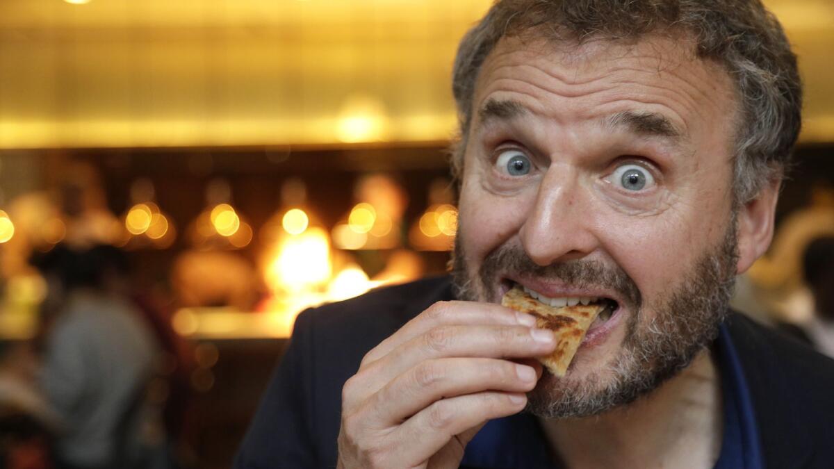 Phil Rosenthal of Netflix's "Somebody Feed Phil," savors the flavors of malawach, a crispy layered bread, during dinner at Bavel.