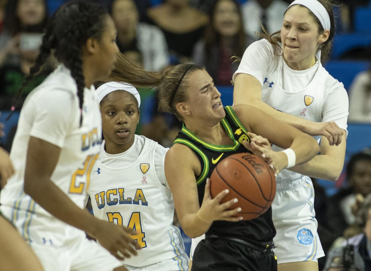 Oregon's Sabrina Ionescu is tied up by UCLA's Lindsey Corsaro, right, during the second quarter of a game Feb. 14 at Pauley Pavilion. 