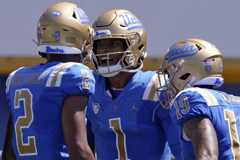 UCLA quarterback Dorian Thompson-Robinson, center, celebrates with wide receiver Titus Mokiao-Atimalala.