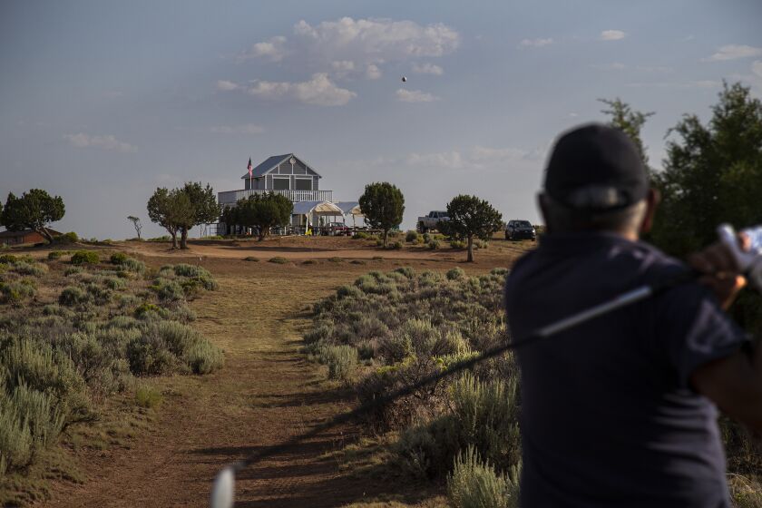 STEAMBOAT, AZ - JULY 19, 2019: Navajo Indian Emmett Francis, 76, tees-off on hole 7 while playing the Rez Golf Course on the Navajo Reservation July 19, 2019 in Steamboat, Arizona. The course is on sprawling parched land filled with native sage, canyons and mostly dirt. The 800-square- foot club house (background) was just built.(Gina Ferazzi/Los AngelesTimes)