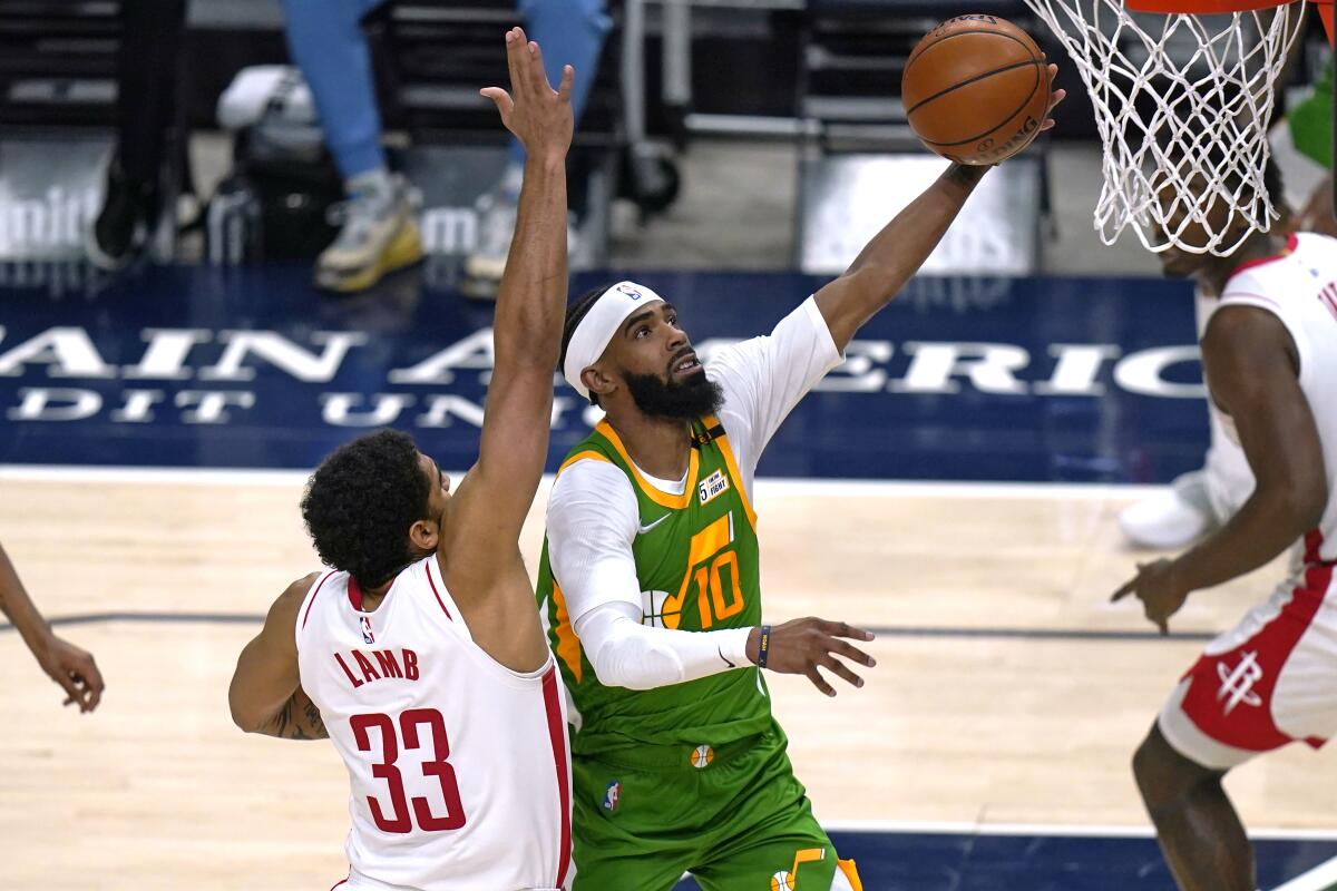 Utah Jazz guard Mike Conley (10) lays the ball up as Houston Rockets Anthony Lamb (33) defends defends during the second half of an NBA basketball game Friday, March 12, 2021, in Salt Lake City. (AP Photo/Rick Bowmer)