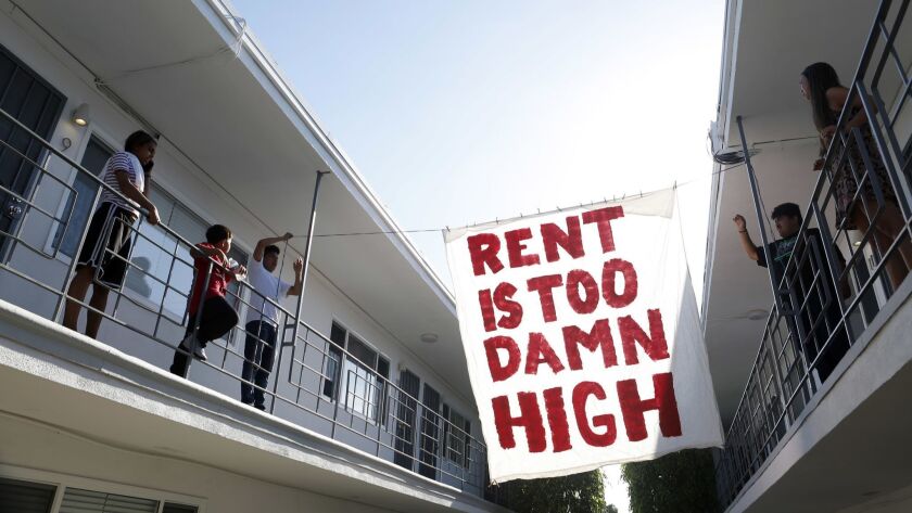An advocacy group hangs a sign in a Long Beach apartment complex.