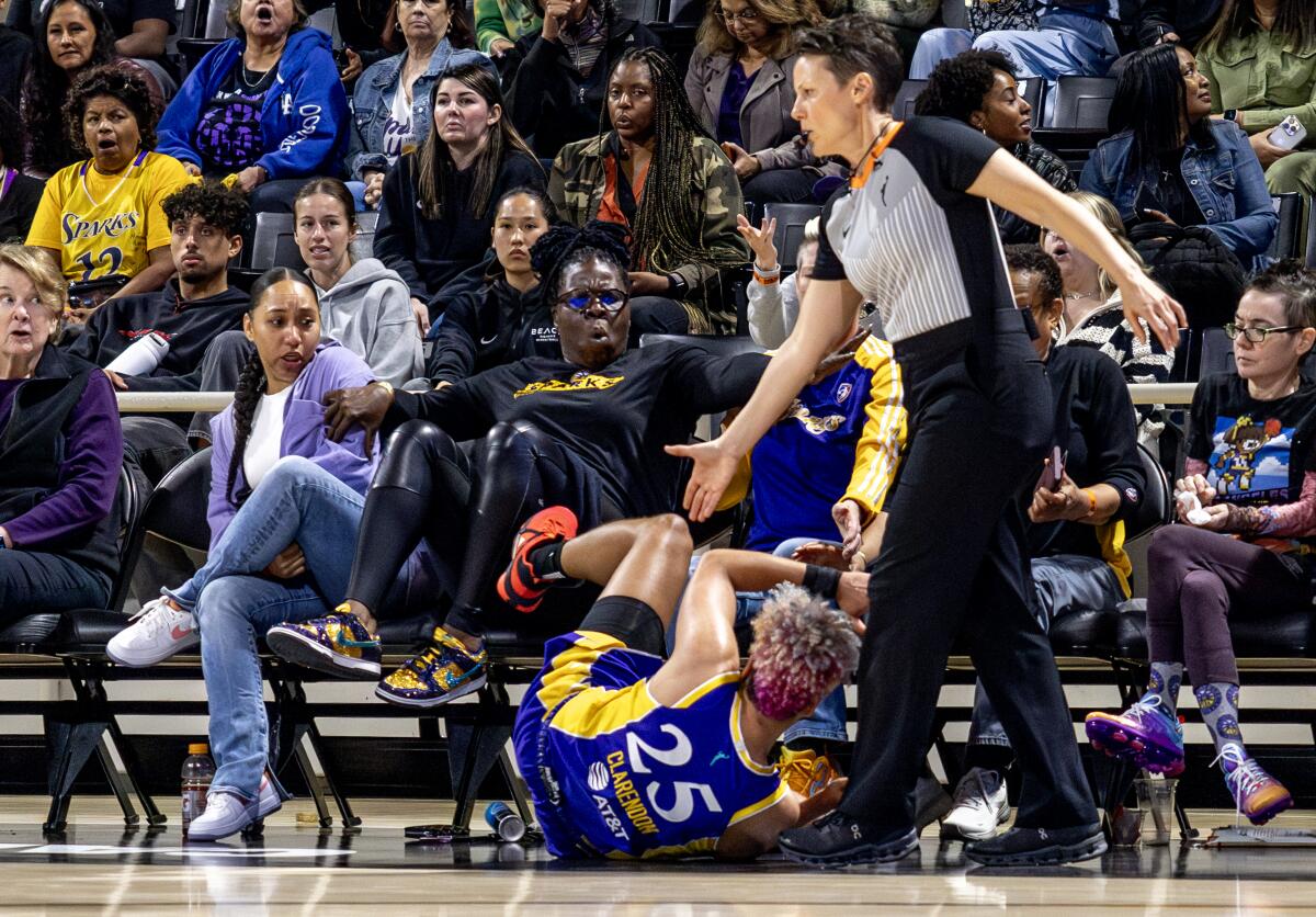 A woman lifts up her feet courtside