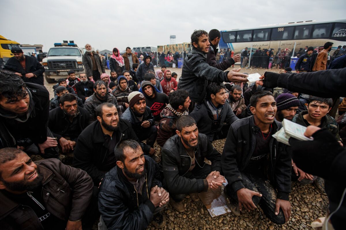 Men fleeing Mosul get their ID cards back after they are screened and cleared of being Islamic State militants.