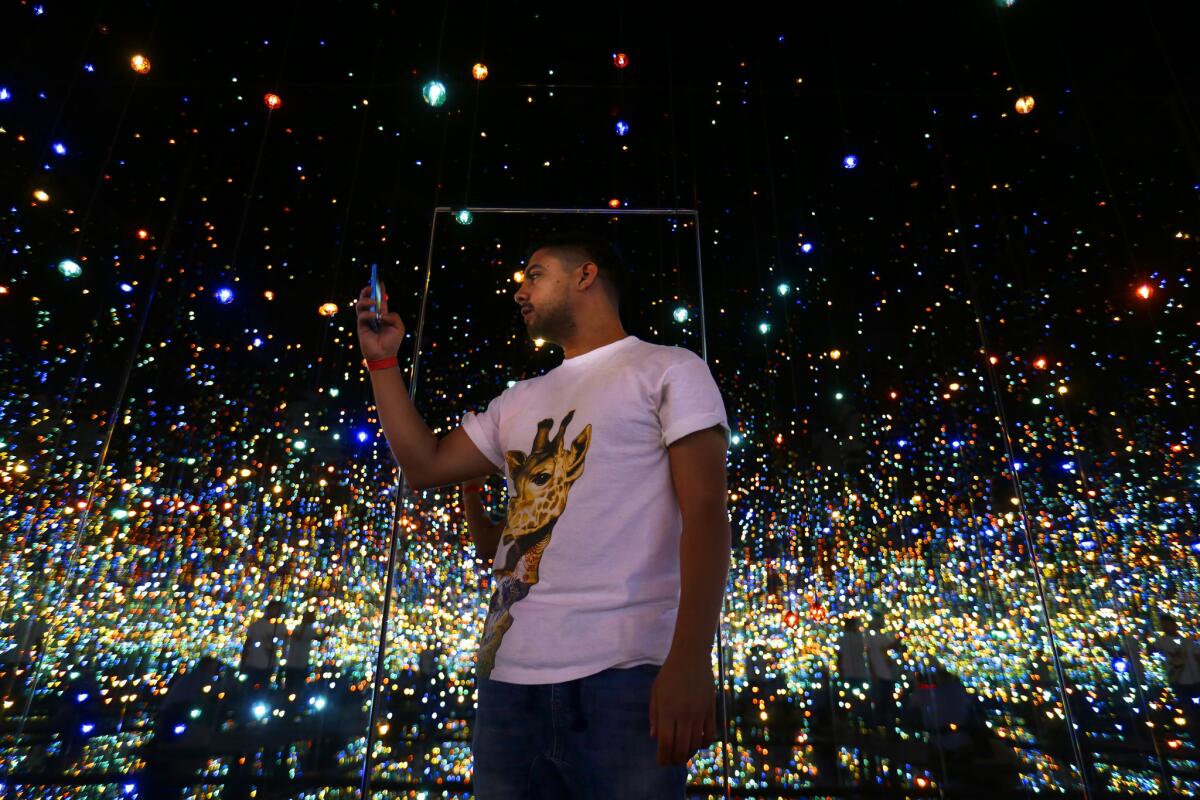 Scott Reyes, 26, of Los Angeles, stands inside Yayoi Kusama's 'Infinity Mirrored Room - The Souls of Millions of Light Years Away' on display at The Broad.