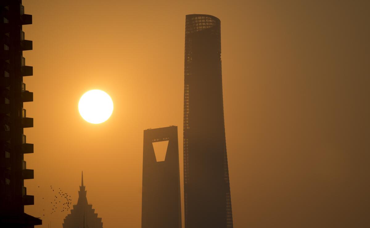 The Shanghai Tower, right, stands 2,073 feet tall, with 128 floors. It was completed in 2015.