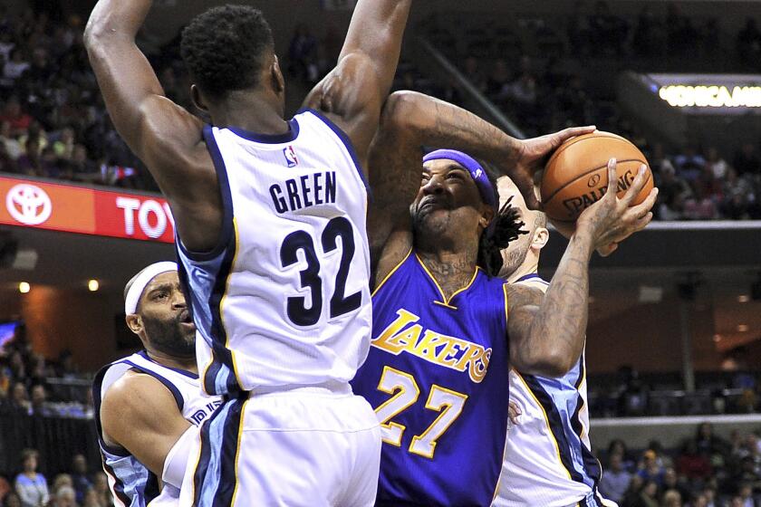 Lakers center Jordan Hill tries to power his way to the basket against Grizzlies forward Jeff Green (32) and guard Nick Calathes (right) in the first half.
