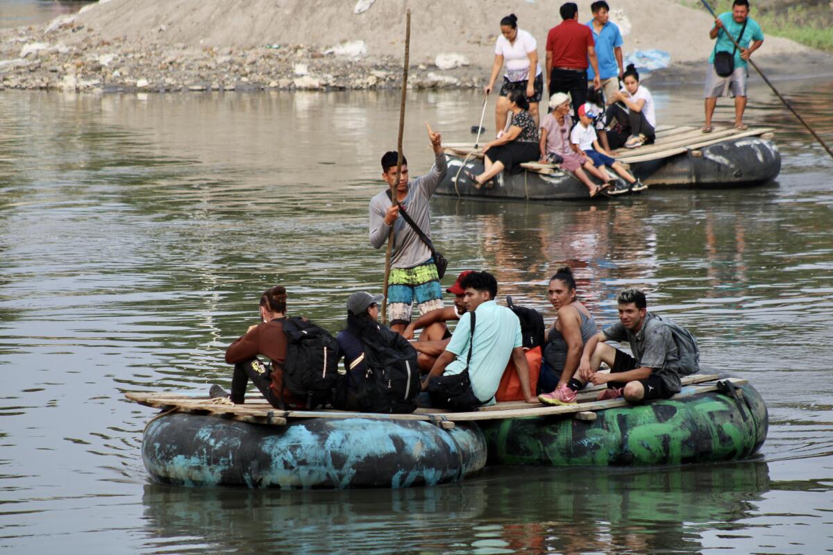 people on crowded makeshift rafts on a river