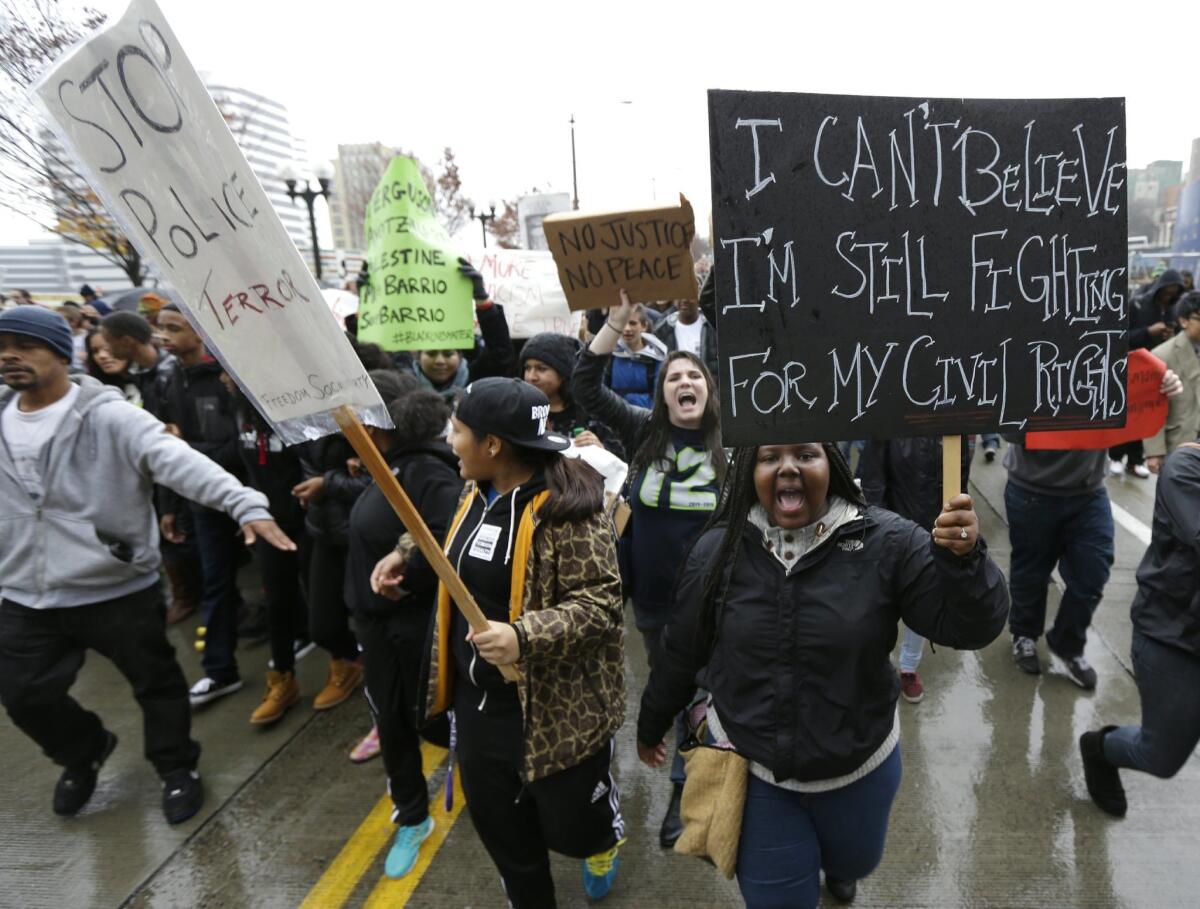 Protesters march in downtown Seattle, Tuesday, Nov. 25, 2014, to demonstrate against a grand jury's decision not to indict police officer Darren Wilson in the killing of Michael Brown. The peaceful march was a mix of students who walked out of schools and a coalition of clergy members. (AP Photo/Ted S. Warren) The Associated Press