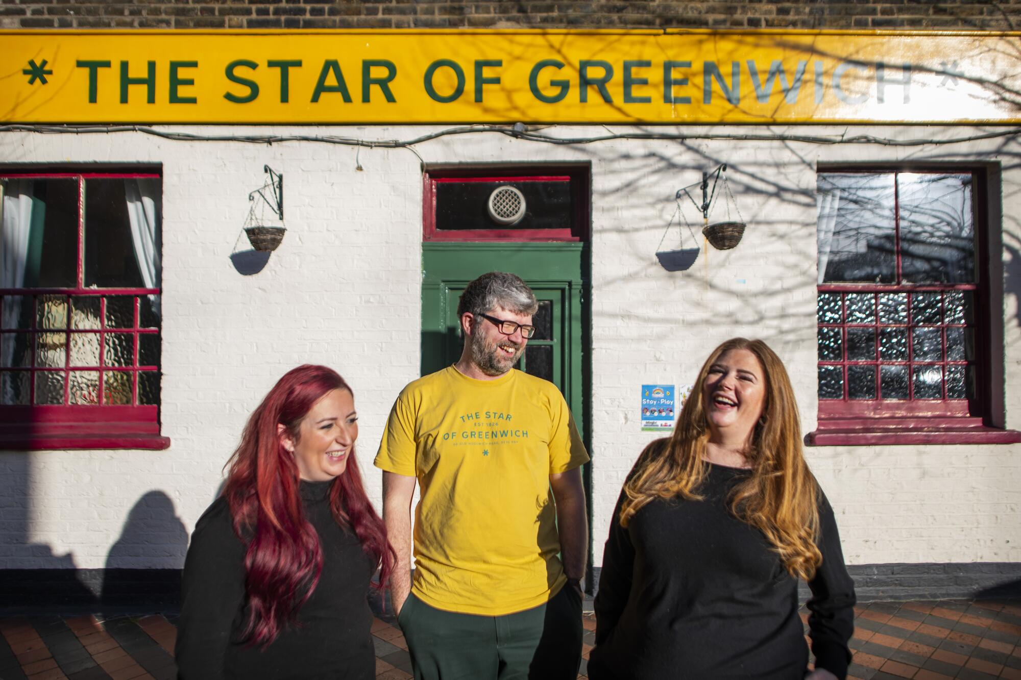 A man and two women stand outside the Star of Greenwich pub 