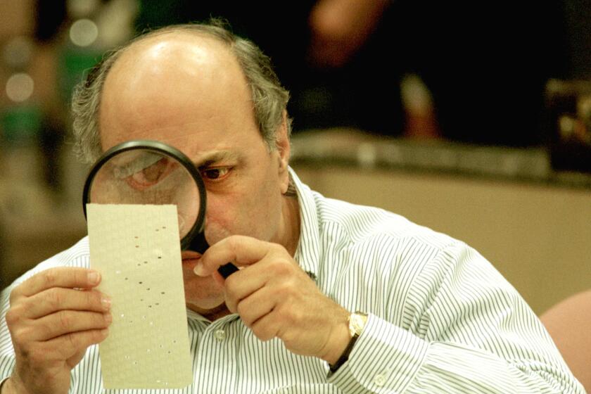 382382 03: (FILE PHOTO) Judge Robert Rosenberg of the Broward County Canvassing Board uses a magnifying glass to examine a dimpled chad on a punch card ballot November 24, 2000 during a vote recount in Fort Lauderdale, Florida. On May 4, 2001 the Florida state legislature overwhelmingly passed a voting reform act designed to eliminate the controversial punch card ballots which were the focal point of recount efforts in the 2000 presidential election. (Photo by Robert King/Newsmakers)