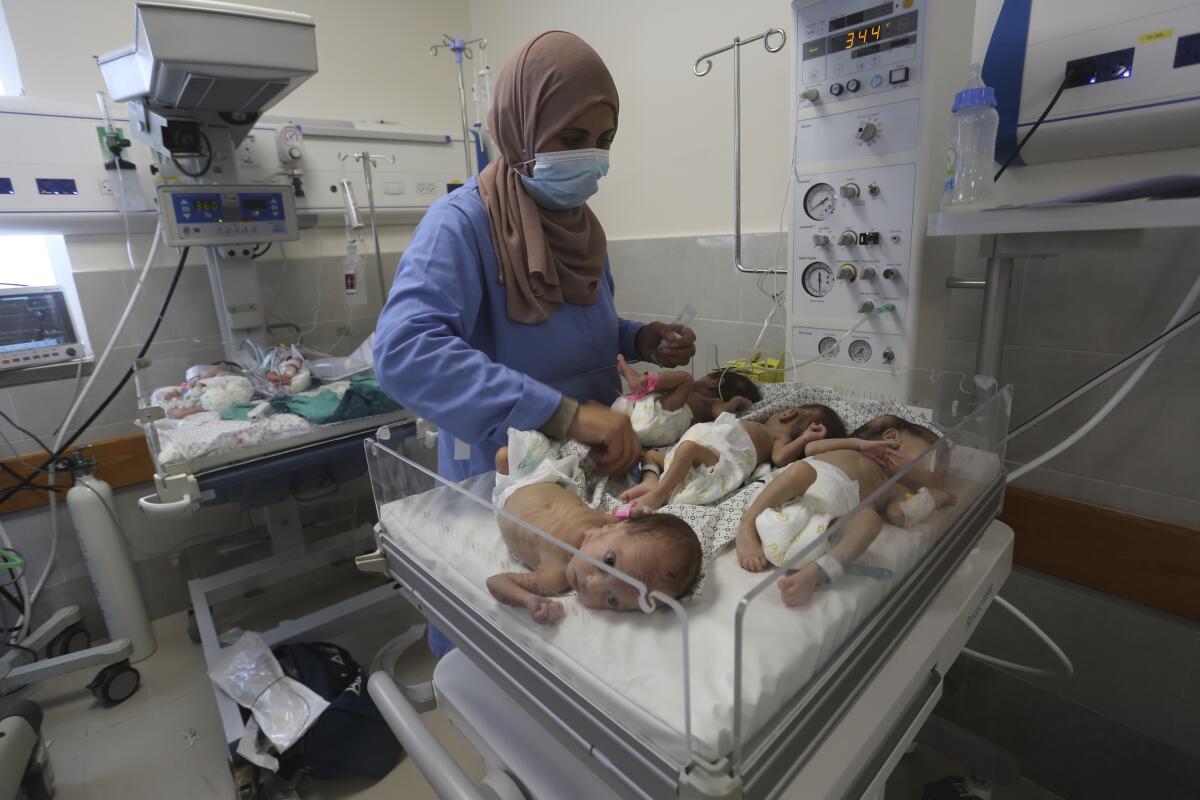 A nurse looks over several prematurely born babies at a hospital.