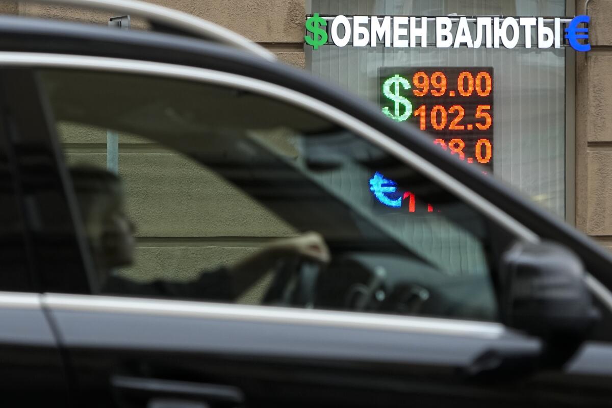 Woman driving past currency exchange office in Moscow