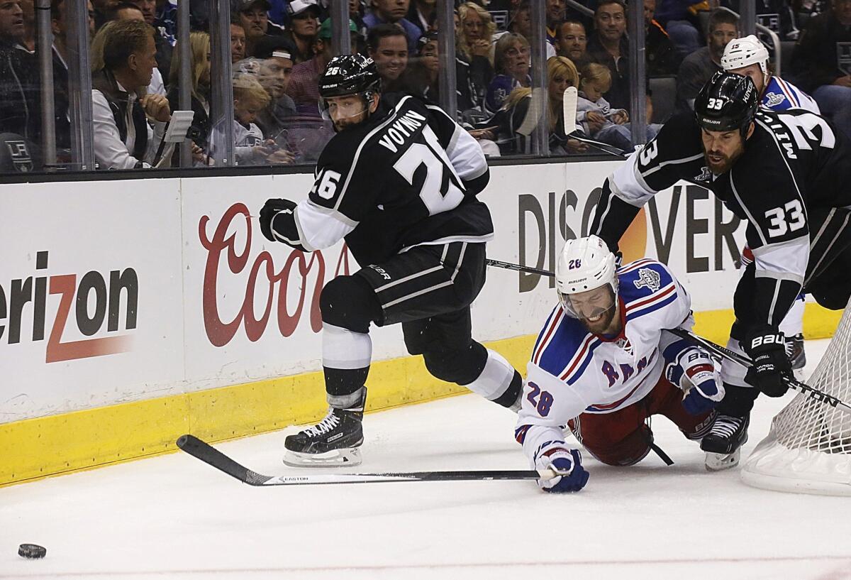 Kings defensemen Willie Mitchell (33), who is knocking down Rangers center Dominic Moore in the first overtime of Game 2, and Slava Voynov have been part of a cohesive rotation that has worked through injuries and fatigue in the playoffs.