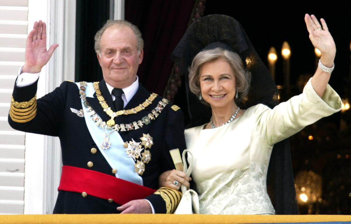 Spanish King Juan Carlos and Queen Sofia wave as they appear on the balcony of the royal palace after the wedding of their son, Crown Prince Felipe, in May 2004.