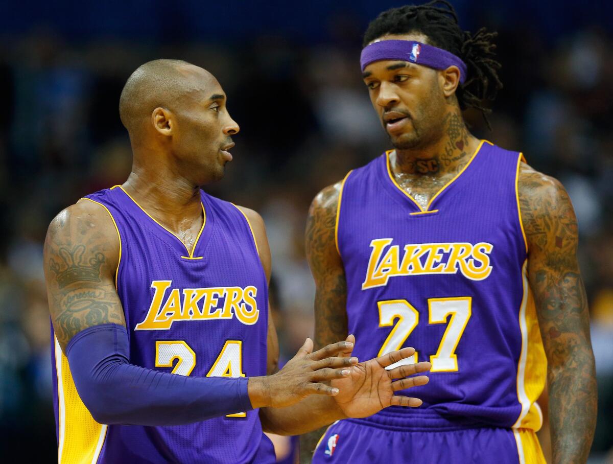Kobe Bryant and Jordan Hill talk during the first quarter of the Lakers' 140-106 loss to the Mavericks on Nov. 21 in Dallas.
