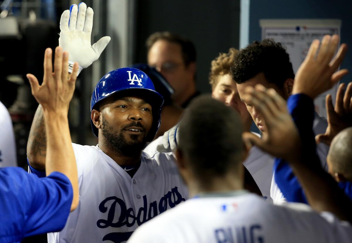 Dodgers second baseman Howie Kendrick is congratulated by teammates after hitting a solo home run against the Diamondbacks on June 9.