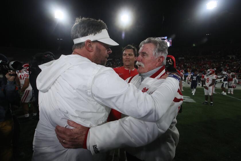 PASADENA, CALIF. - NOV. 25, 2022, St. John Bosco head coach Jason Negro, left, shakes hands with Mater Dei head coach Bruce Rollinson after d the CIF Southern. Section Championship Game at the Rose Bowl in Pasadena on Friday night, Nov. 25, 2022. Bosco won, 24-22. (Luis Sinco / Los Angeles Times)