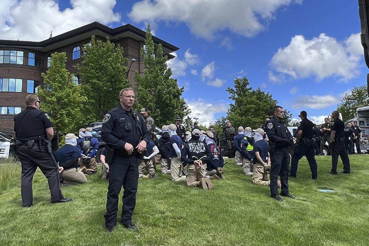 Police guard members of a white supremacist group after their arrests Saturday in Coeur d’Alene, Idaho.