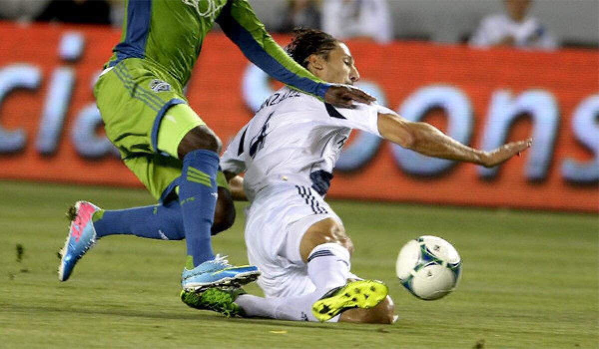 The Galaxy's Omar Gonzalez slides for the ball in front of Eddie Johnson of the Sounders on May 26, 2012.
